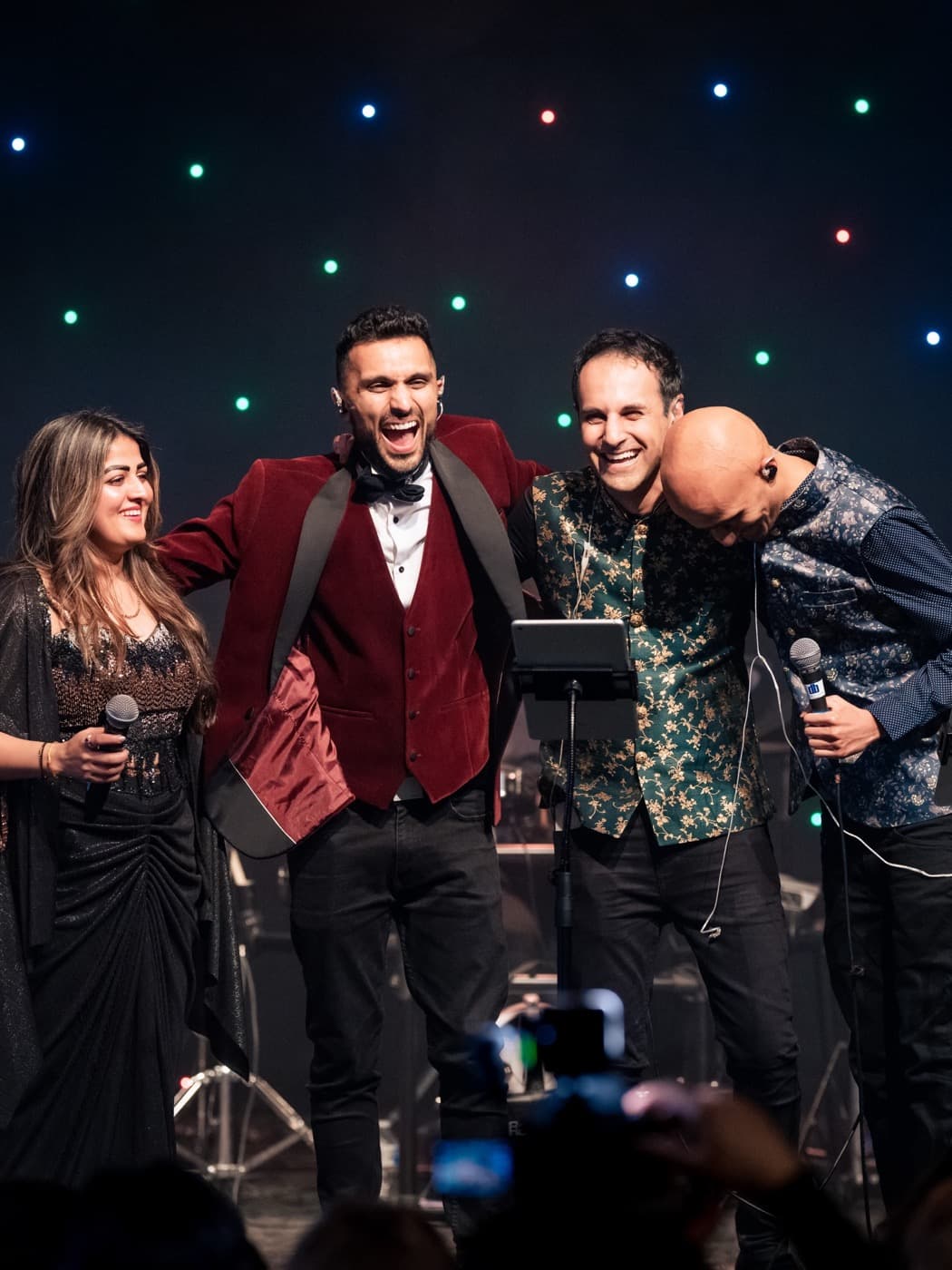 Paras laughing with fellow singers on stage at the end of a live show